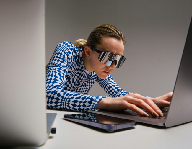 kvinna med solglasögon framför datorskärm