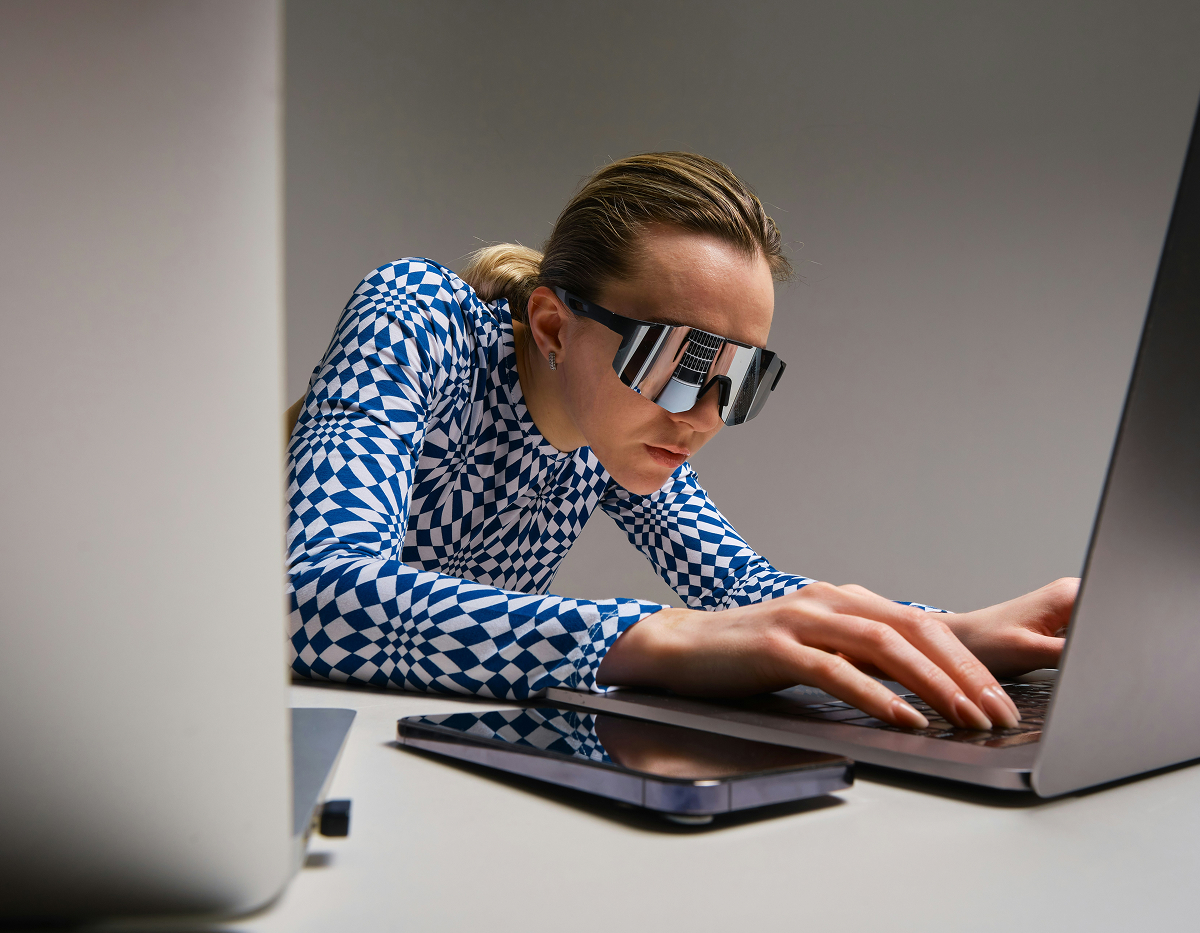 kvinna med solglasögon framför datorskärm