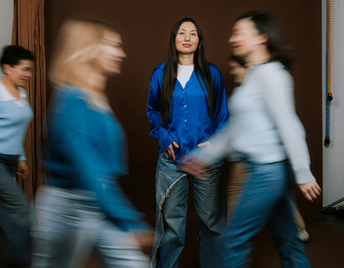 En kvinna står stilla mitt i en folkmassa, medan personer runt omkring rör sig förbi och blir suddiga pga motion blur.