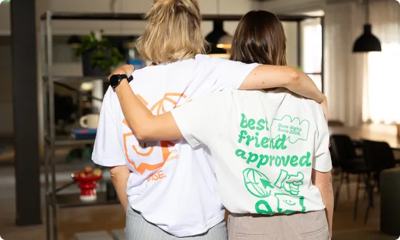 Two people in white t-shirts holding each other over the shoulders.