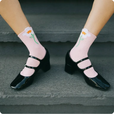 Feet in pink socks and black high heels.