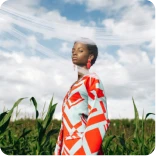 Woman in colorful dress walking through high grass field