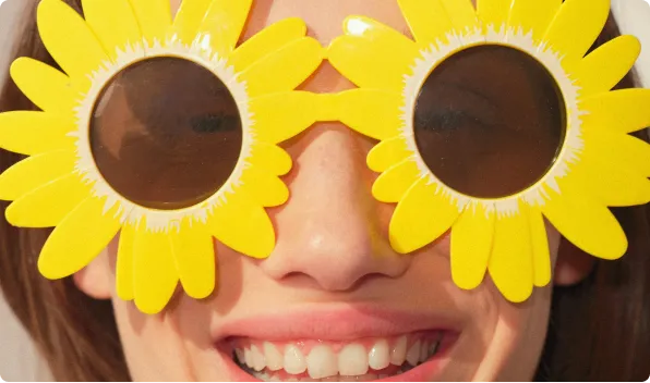 Smiling female in sun glasses with sun flower design.