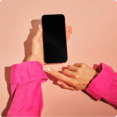Female with pink shirt holding up her mobile phone