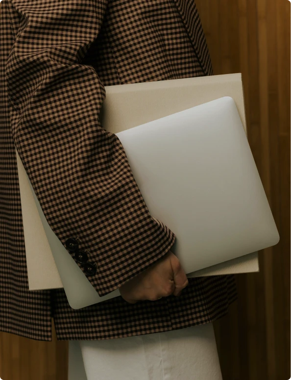Person in checkered jacket holding a computer.
