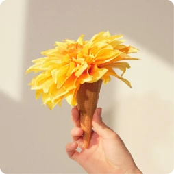 Hand holding a yellow flower