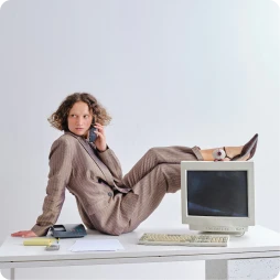 Woman in suit with her feet placed above a computer