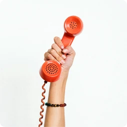 Hand holding up an orange landline